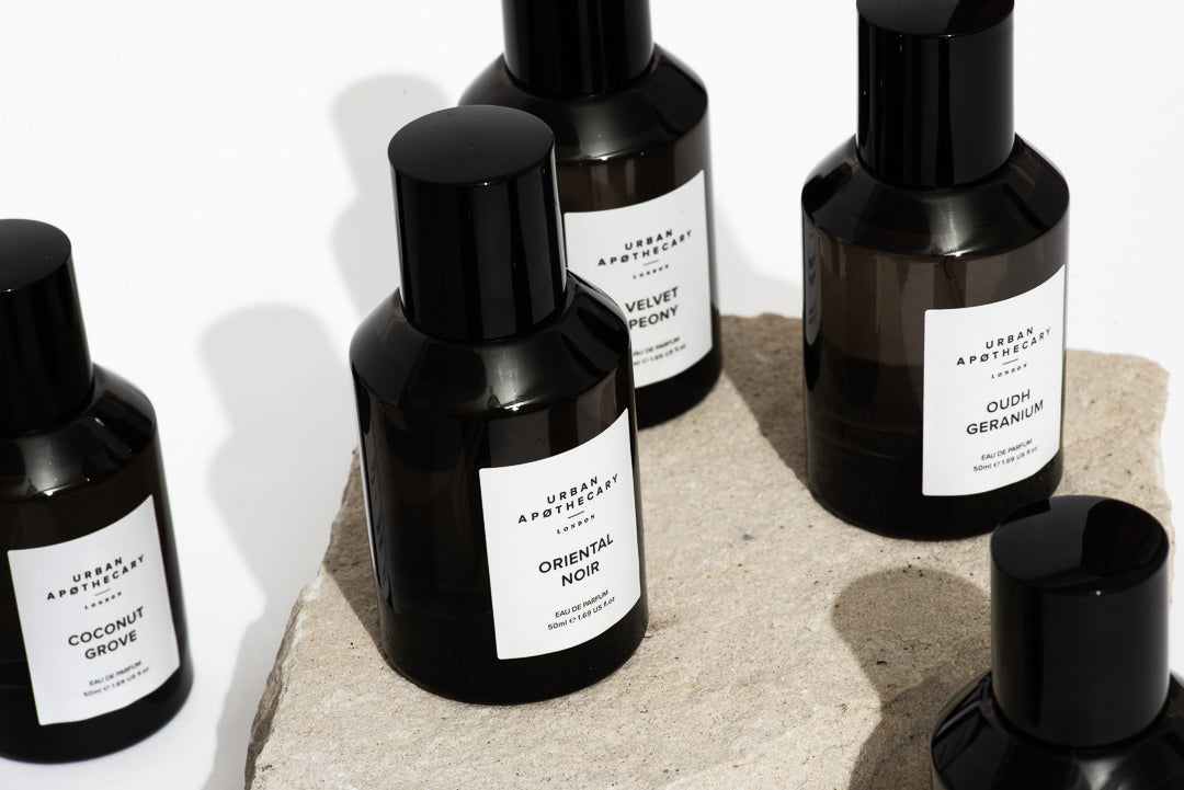 Set of black perfume bottles with labels on a light background