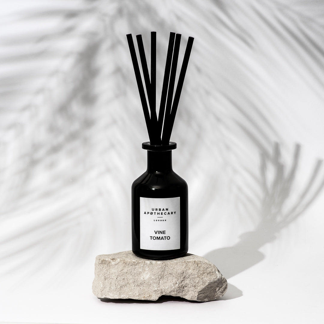 Black diffuser bottle labeled 'Vine Tomato' by Urban Apothecary on a stone surface with a white background