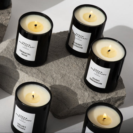 Collection of black candles with white labels on a light background