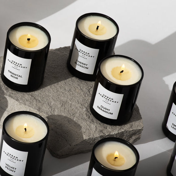 Collection of black candles with white labels on a light background