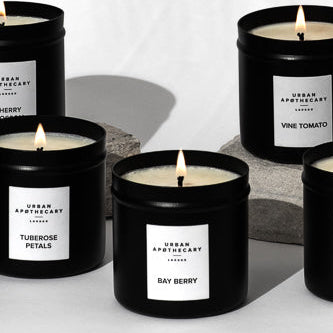 Row of black candles with white labels on a white background