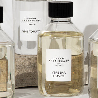 Row of diffuser refill bottles with labels on a white background