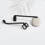 Urban Apothecary London's wick trimmer and candle snuffer resting on a stone